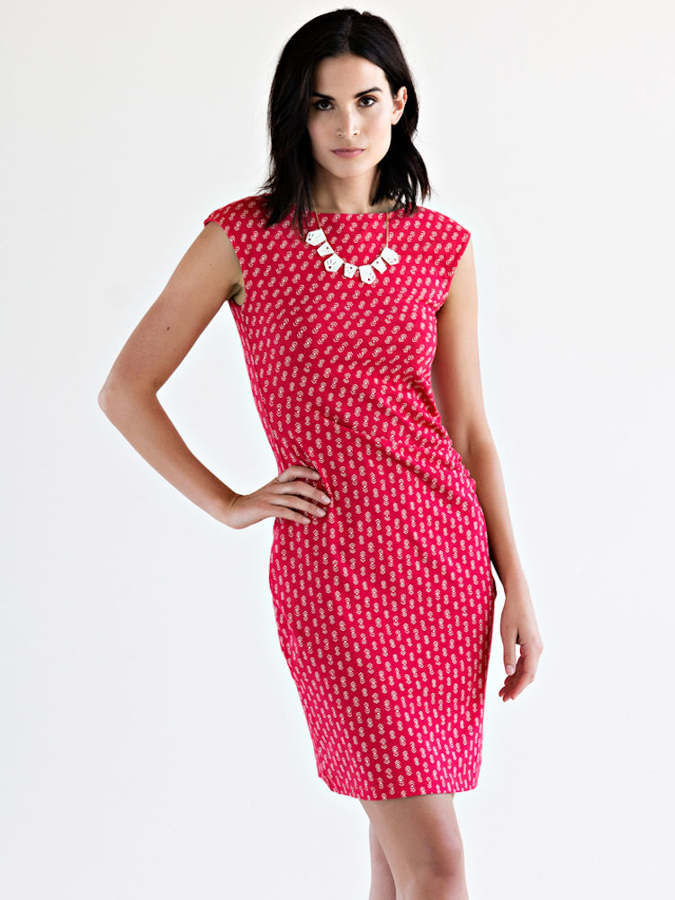 A woman wearing a fitted red print dress from an ethical dress brand.