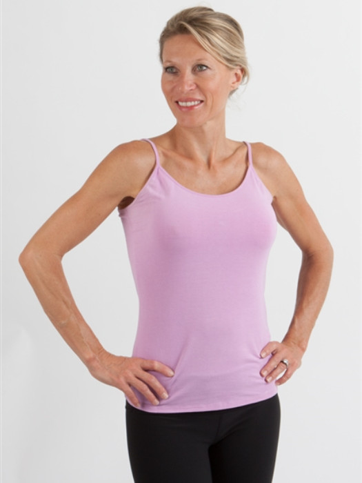 A woman wearing pink camisole and black pants from a minimalist capsule wardrobe.